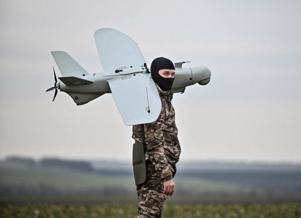 Ukrainian soldier carrying inexpensive battlefield drone used for reconaissance.